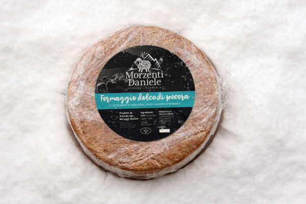 formaggio-di-pecora-stagionato-sette-mesi-forma-intera-etichettata-sfondo-neve
